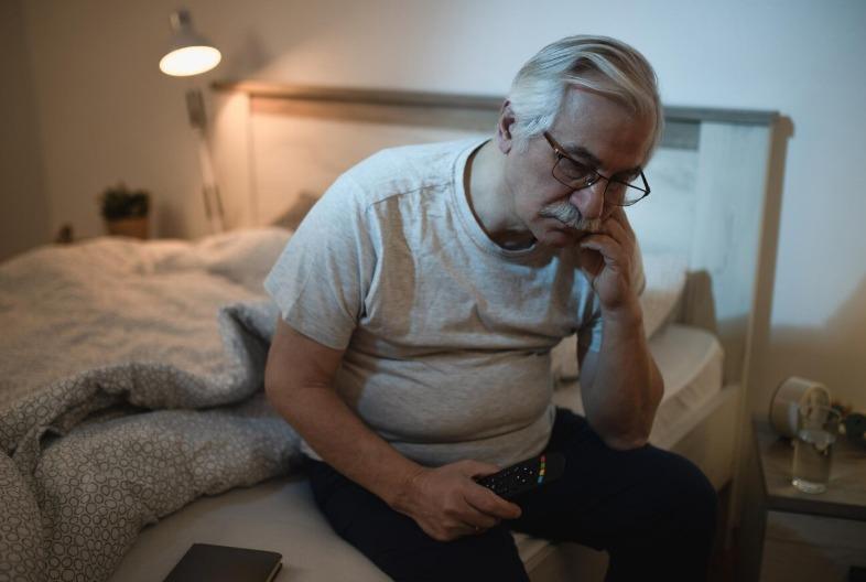 Elderly man holding stomach in pain due to diarrhoea discomfort